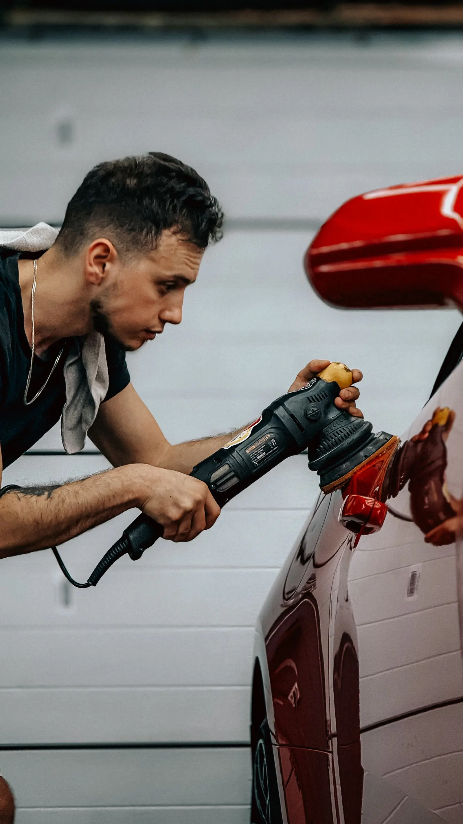 Detailer polishing a red car